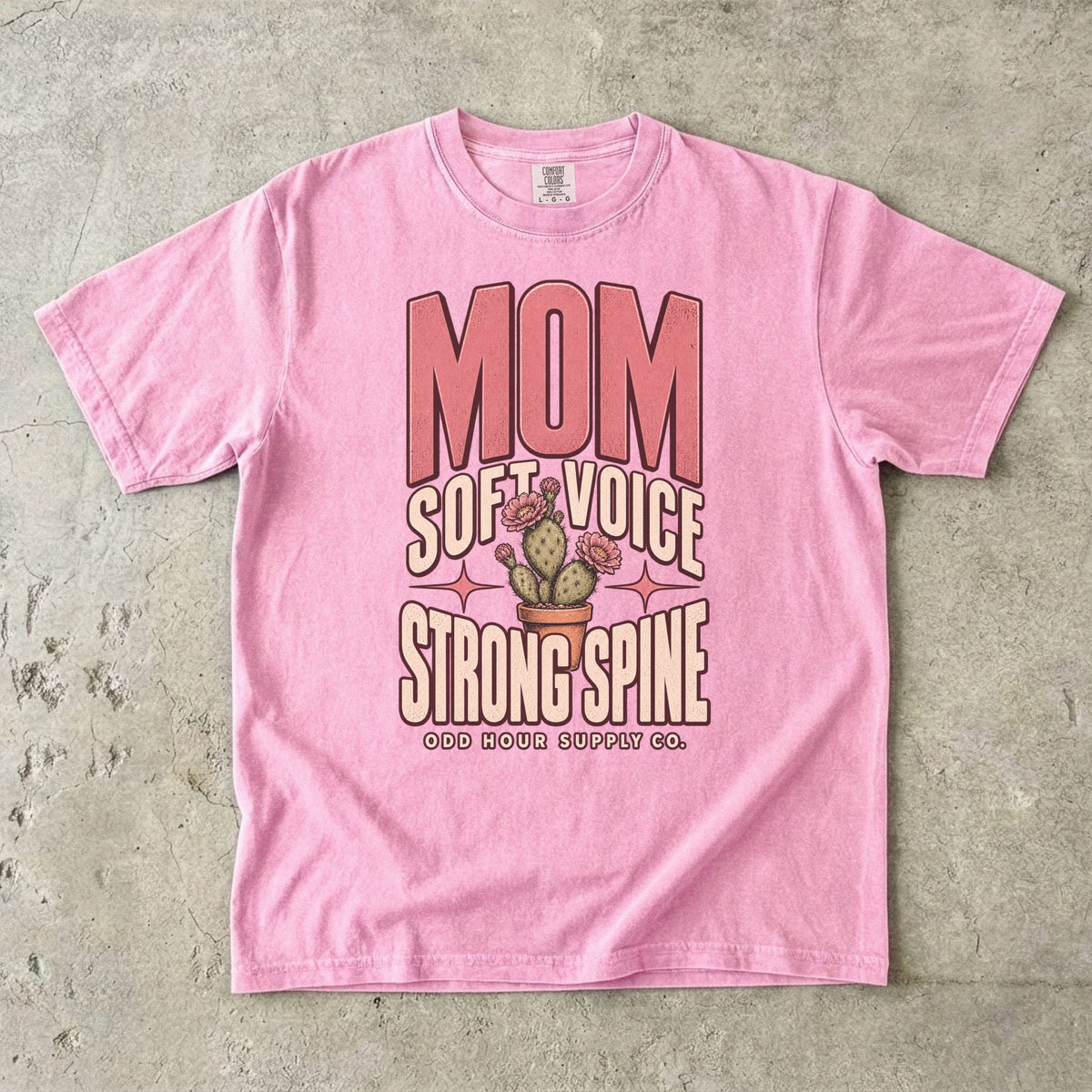 Blossom Comfort Colors 1717 T-shirt with pink Mom lettering, Soft Voice Strong Spine text, and a flowering cactus in a terracotta pot.