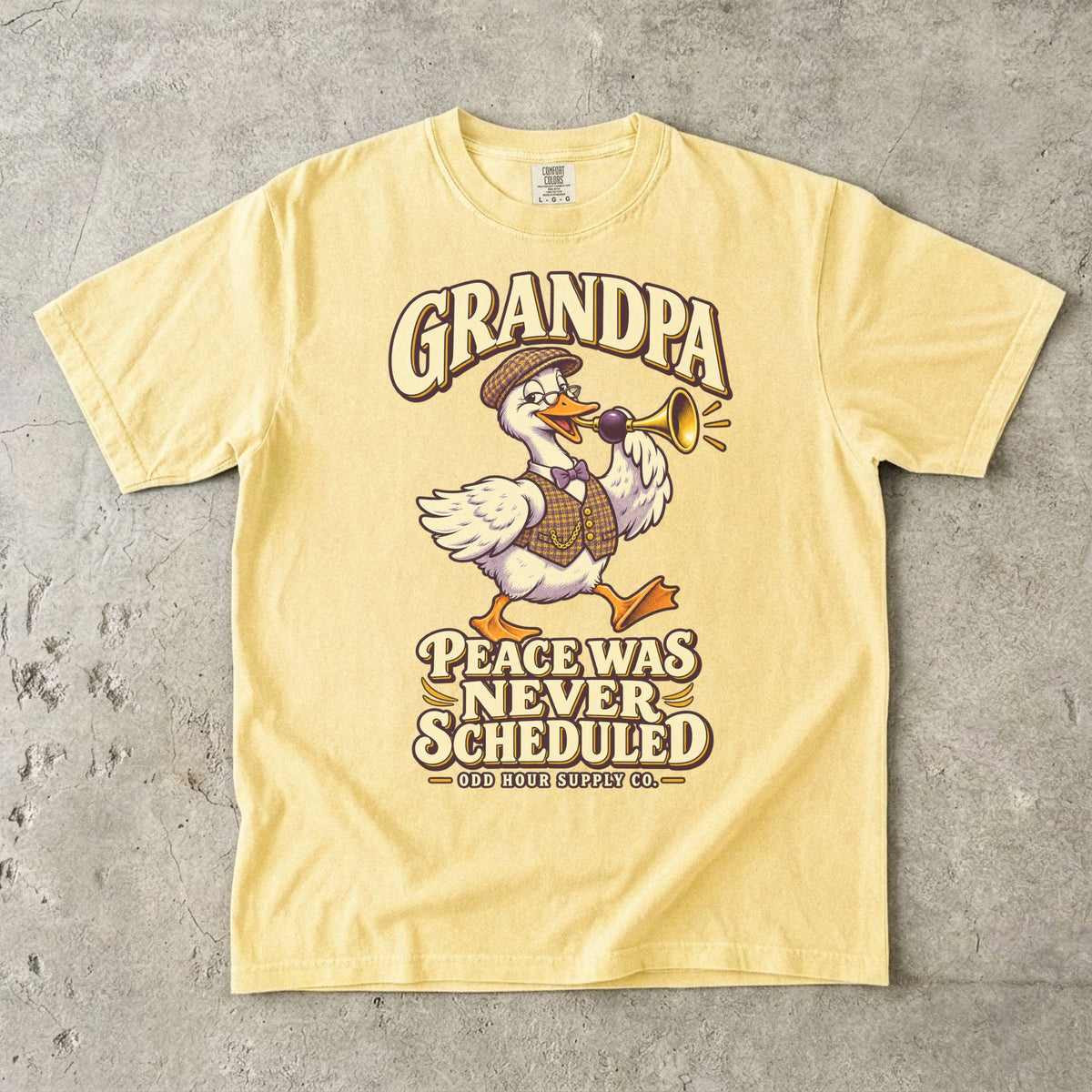 Butter T-shirt with GRANDPA PEACE WAS NEVER SCHEDULED and a goose wearing glasses and a flat cap, holding a horn, by Odd Hour Supply Co.