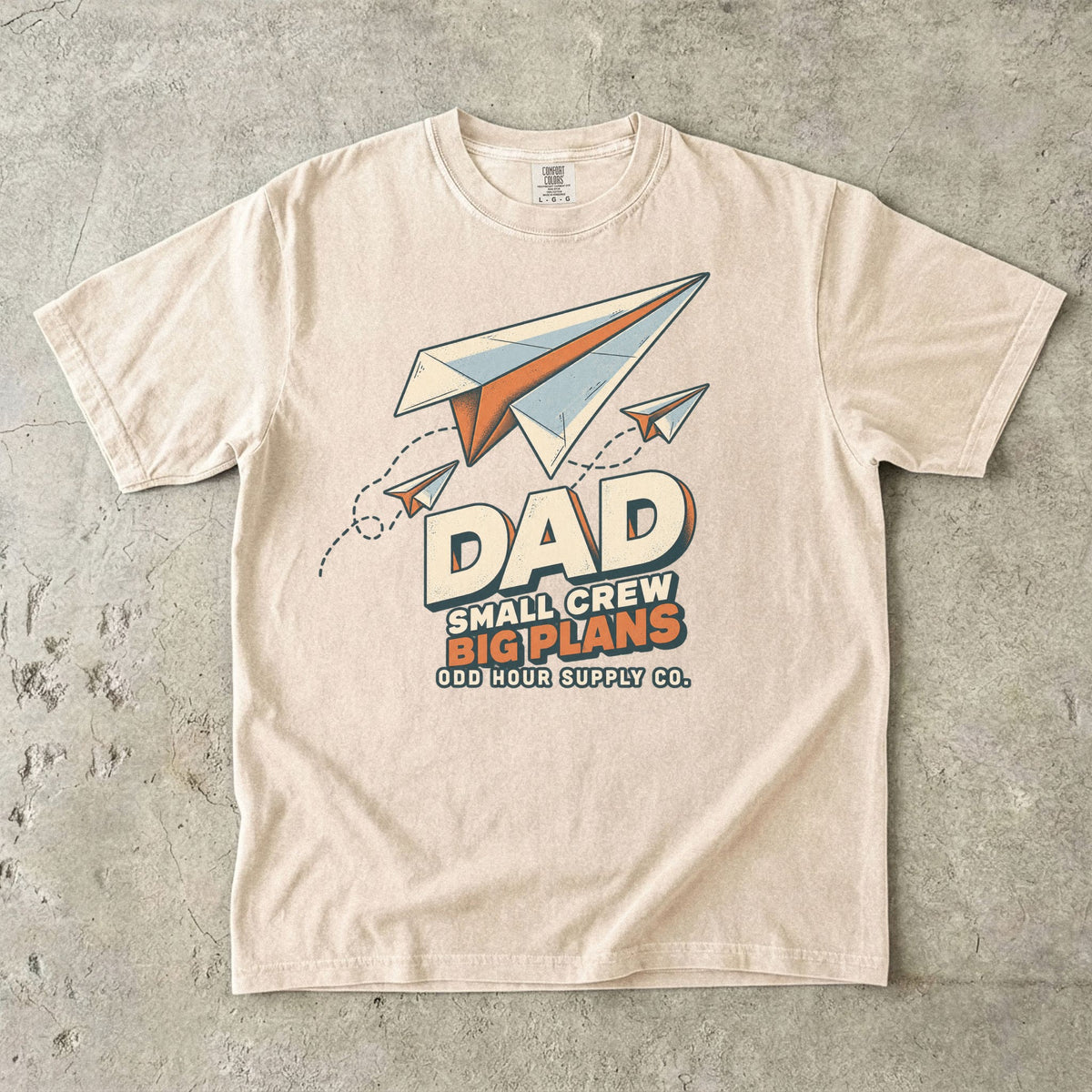Ivory Comfort Colors 1717 T-shirt with three paper planes, dotted flight paths, and Dad Small Crew Big Plans lettering.