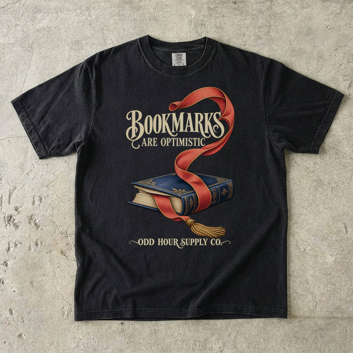 Black T-shirt featuring a blue book, red bookmark and BOOKMARKS ARE OPTIMISTIC by Odd Hour Supply Co.
