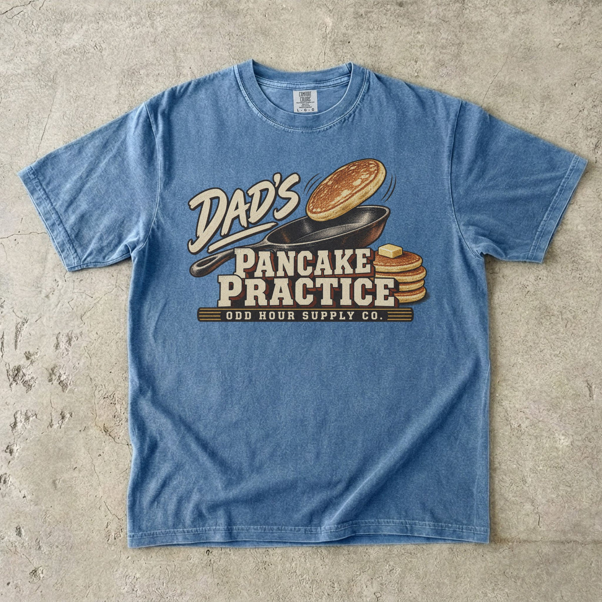 Blue Jean Comfort Colors 1717 T-shirt with a cast-iron pan, an airborne pancake, a pancake stack with butter, and Dad’s Pancake Practice lettering.