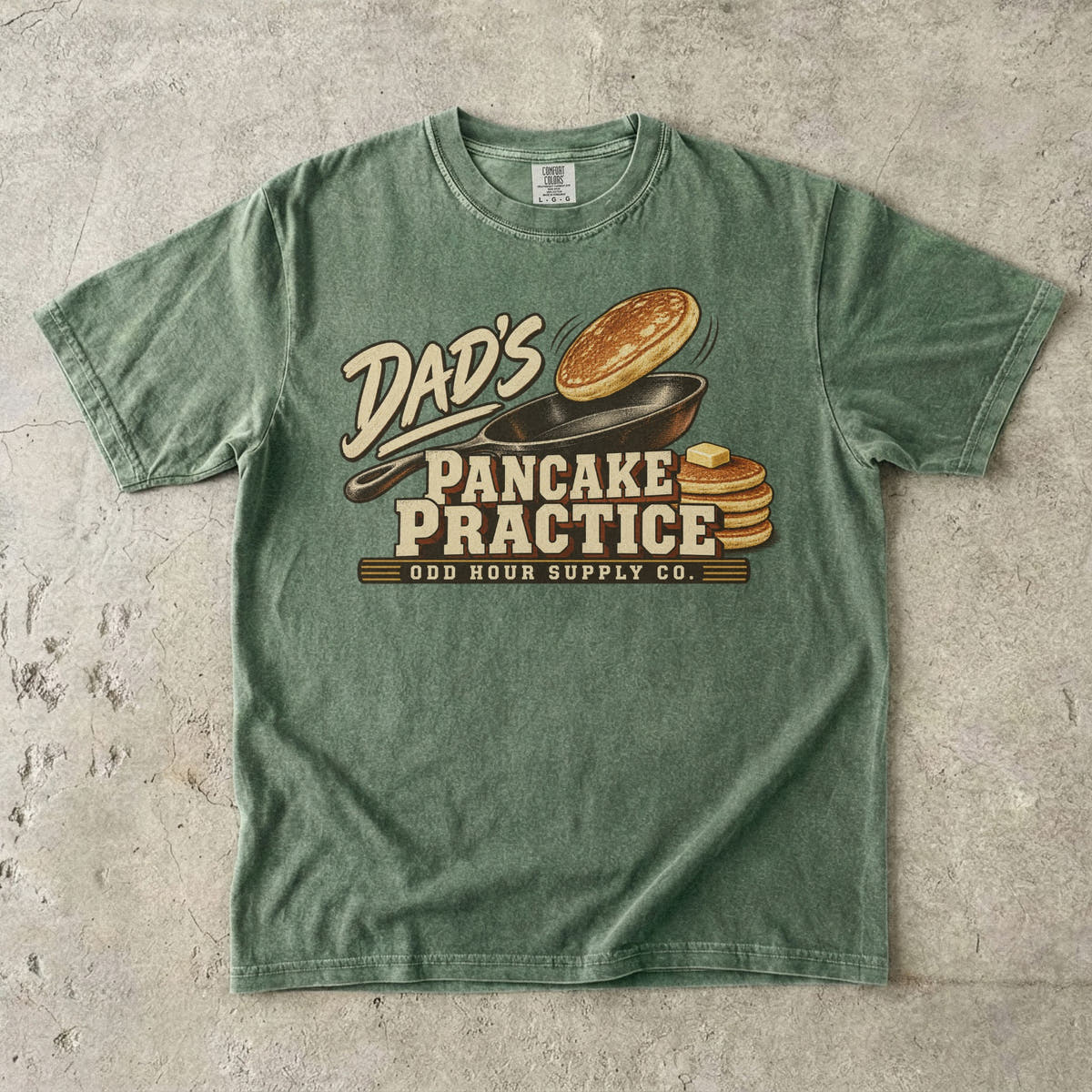 Moss Comfort Colors 1717 T-shirt with a cast-iron pan, an airborne pancake, a pancake stack with butter, and Dad’s Pancake Practice lettering.