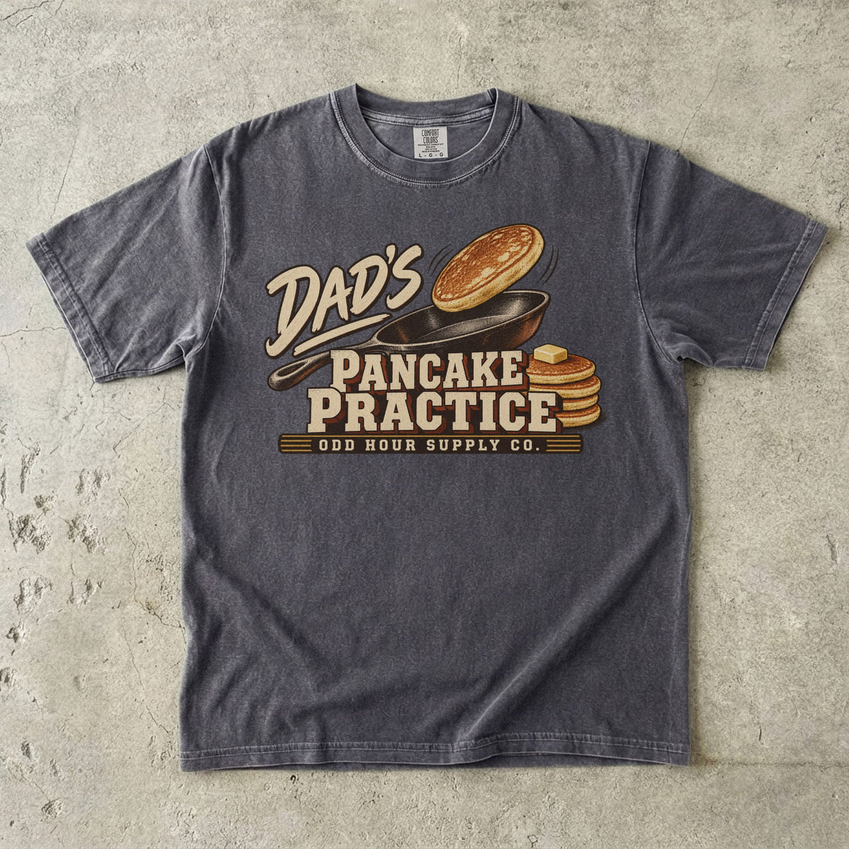 Pepper Comfort Colors 1717 T-shirt with a cast-iron pan, an airborne pancake, a pancake stack with butter, and Dad’s Pancake Practice lettering.