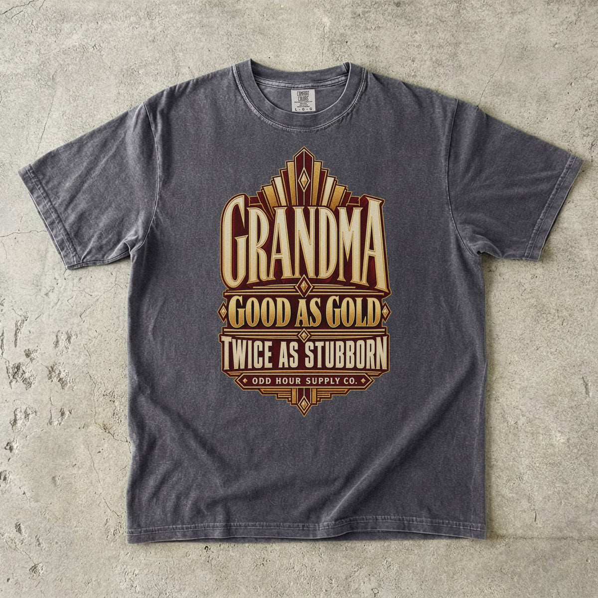 Pepper Comfort Colors 1717 T-shirt with gold geometric lines and Grandma Good as Gold Twice as Stubborn lettering on a burgundy panel.