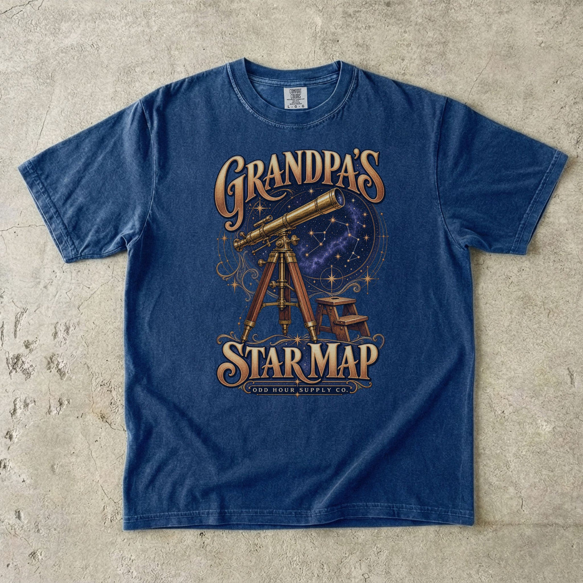 True Navy T-shirt with GRANDPA’S STAR MAP, a brass telescope, a starry sky and a small stool by Odd Hour Supply Co.