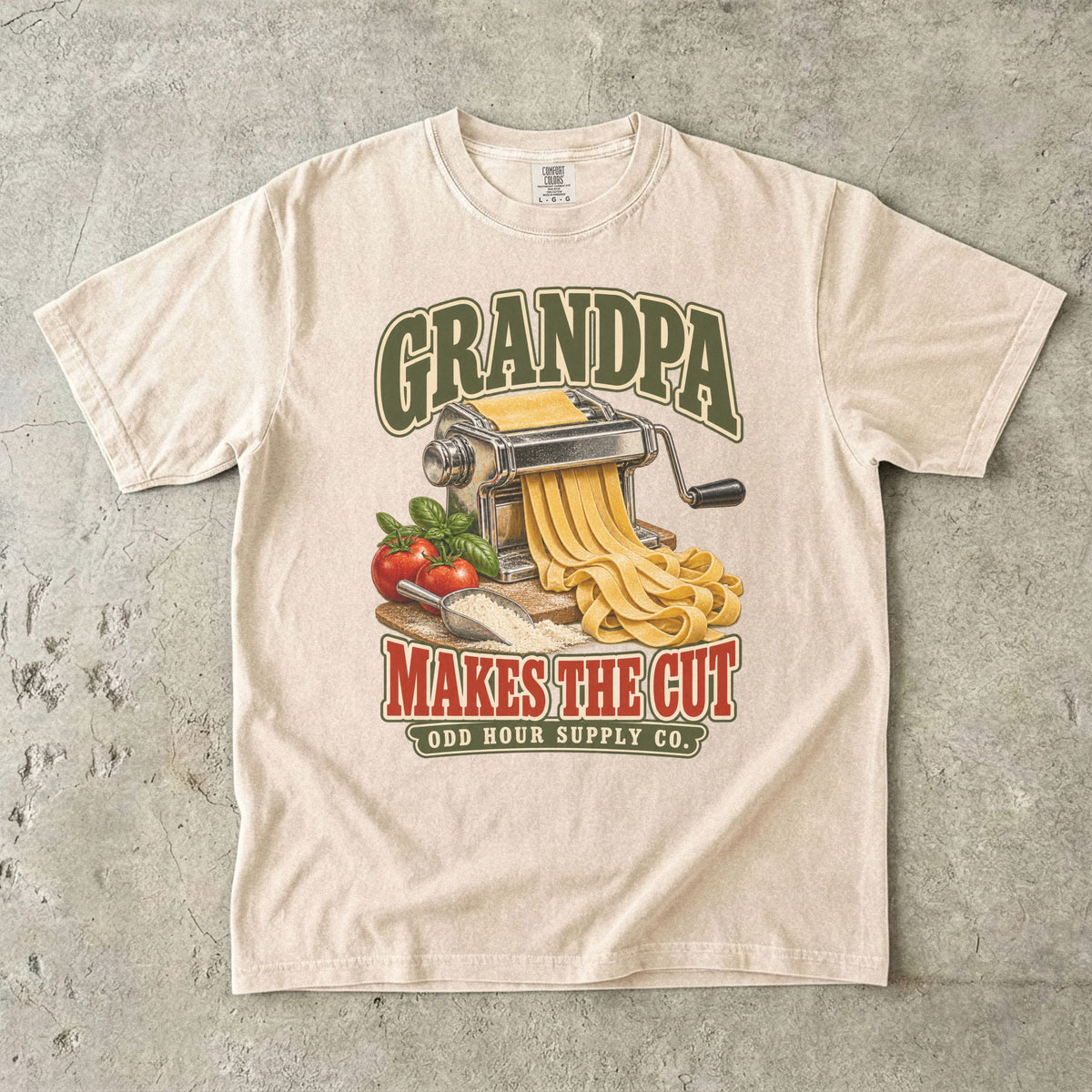 Ivory T-shirt with GRANDPA MAKES THE CUT, a pasta machine, noodles, tomatoes and basil by Odd Hour Supply Co.