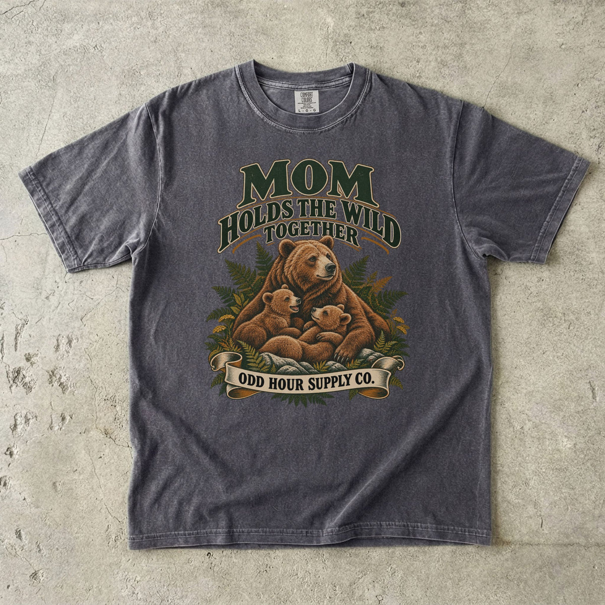 Pepper Comfort Colors 1717 T-shirt with a mother bear, two cubs, ferns, and Mom Holds the Wild Together lettering.