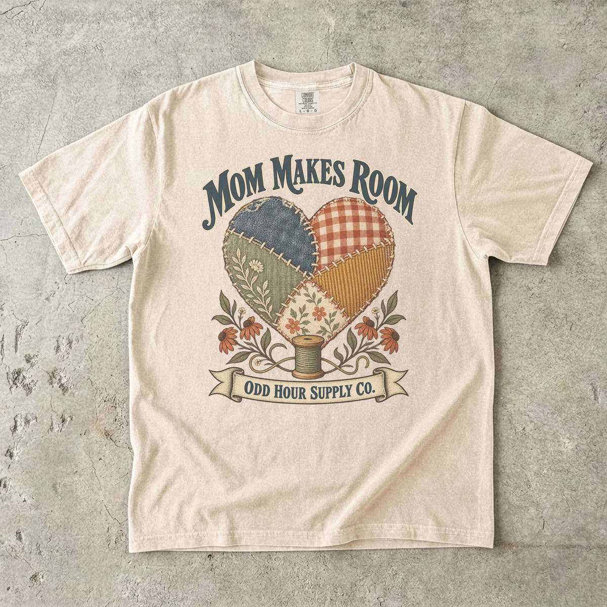 Ivory Comfort Colors 1717 T-shirt with a heart made of patterned fabric patches, flowers, a spool of thread, and Mom Makes Room lettering.