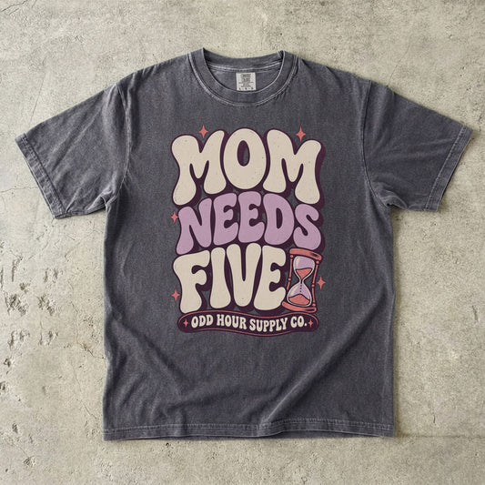Pepper Comfort Colors 1717 T-shirt with cream and lilac Mom Needs Five lettering, pink stars, and an hourglass.