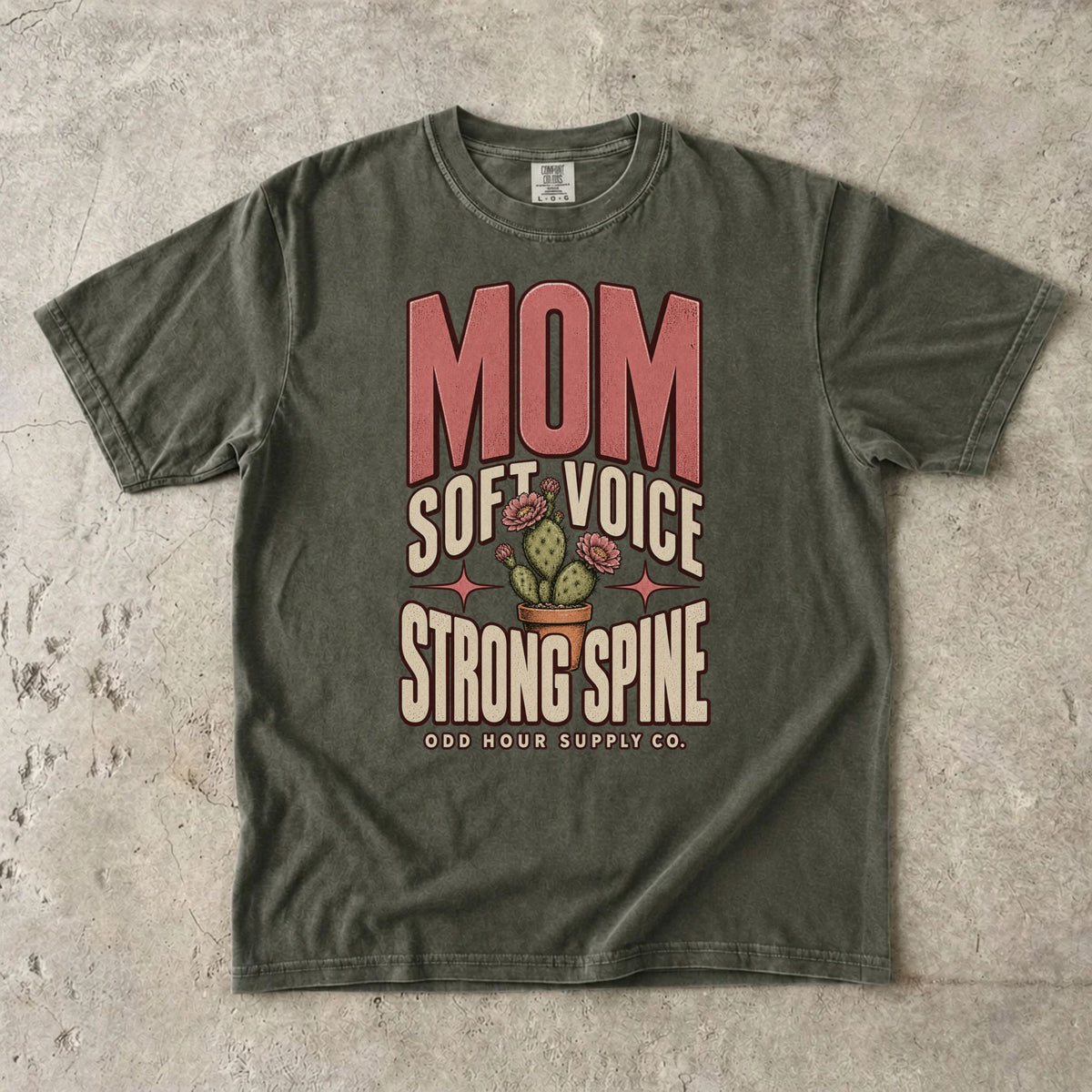 Sage Comfort Colors 1717 T-shirt with pink Mom lettering, Soft Voice Strong Spine text, and a flowering cactus in a terracotta pot.