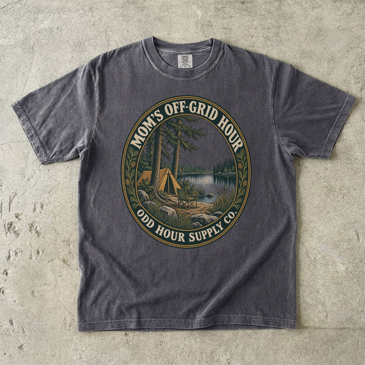 Pepper Comfort Colors 1717 T-shirt with an oval Mom’s Off-Grid Hour badge showing a tent, a camp chair, pine trees, and a lake.
