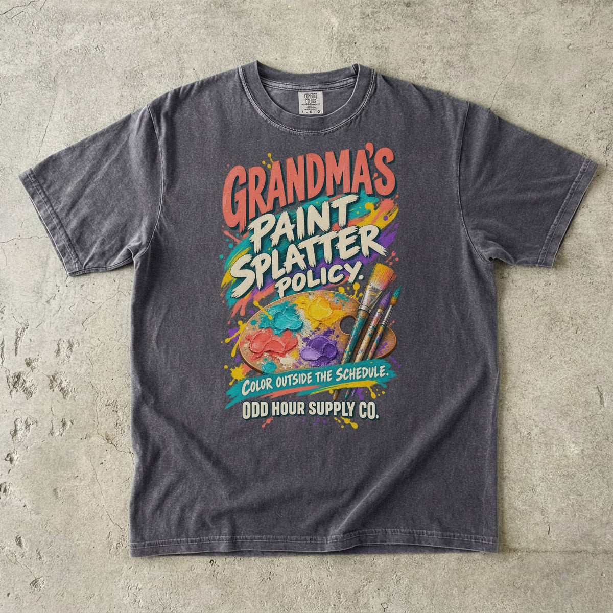 Pepper Comfort Colors 1717 T-shirt with an artist’s palette, paintbrushes, paint splashes, and Grandma’s Paint Splatter Policy and Color Outside the Schedule lettering.