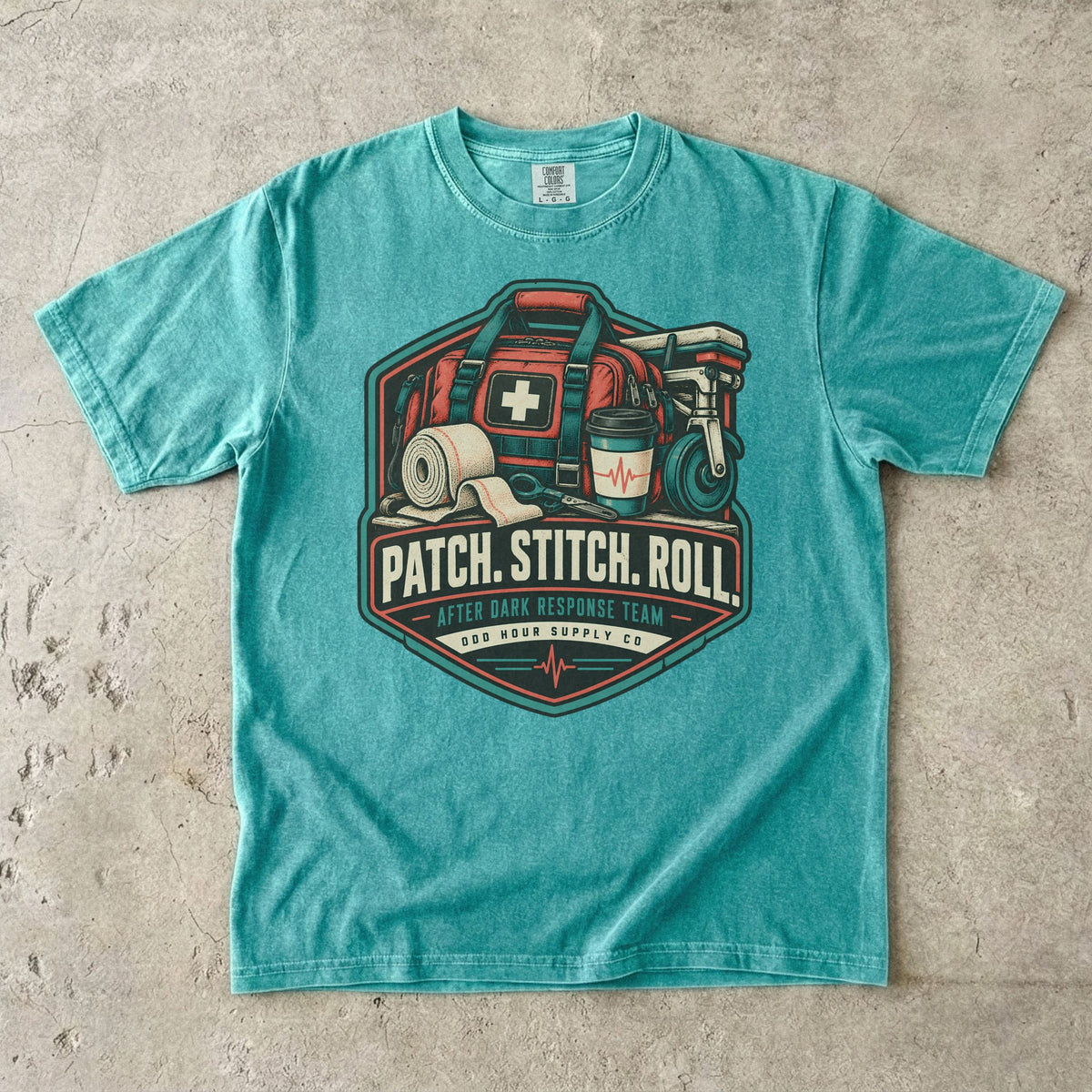 Seafoam Comfort Colors 1717 T-shirt with Patch Stitch Roll badge, coral medical bag, bandages, coffee cup and teal details.