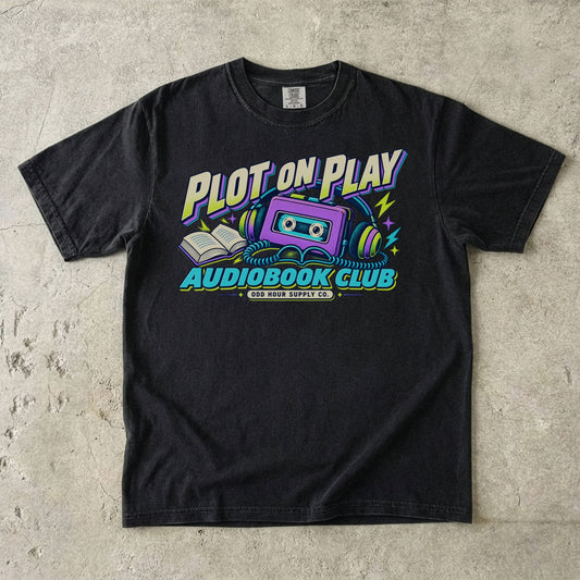 Black T-shirt featuring a purple cassette, headphones and PLOT ON PLAY AUDIOBOOK CLUB by Odd Hour Supply Co.