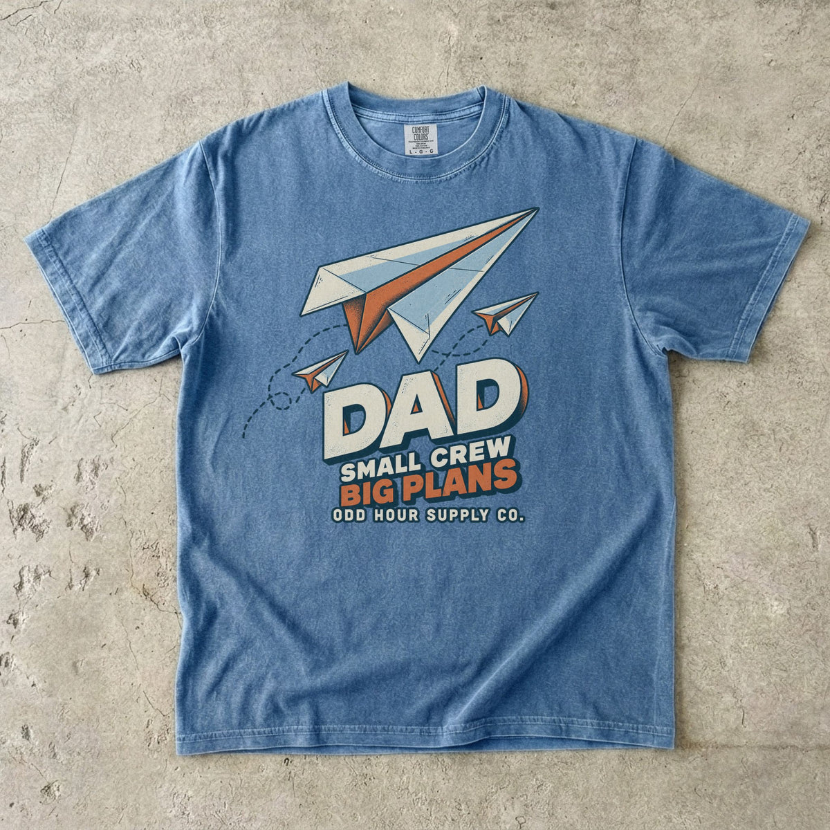 Blue Jean Comfort Colors 1717 T-shirt with three paper planes, dotted flight paths, and Dad Small Crew Big Plans lettering.