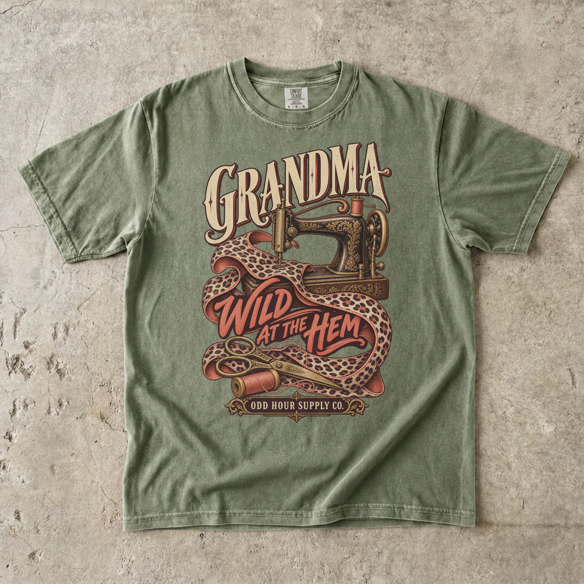 Hemp Comfort Colors 1717 T-shirt with an ornate sewing machine, leopard-print fabric, thread spools, and Grandma Wild at the Hem lettering.