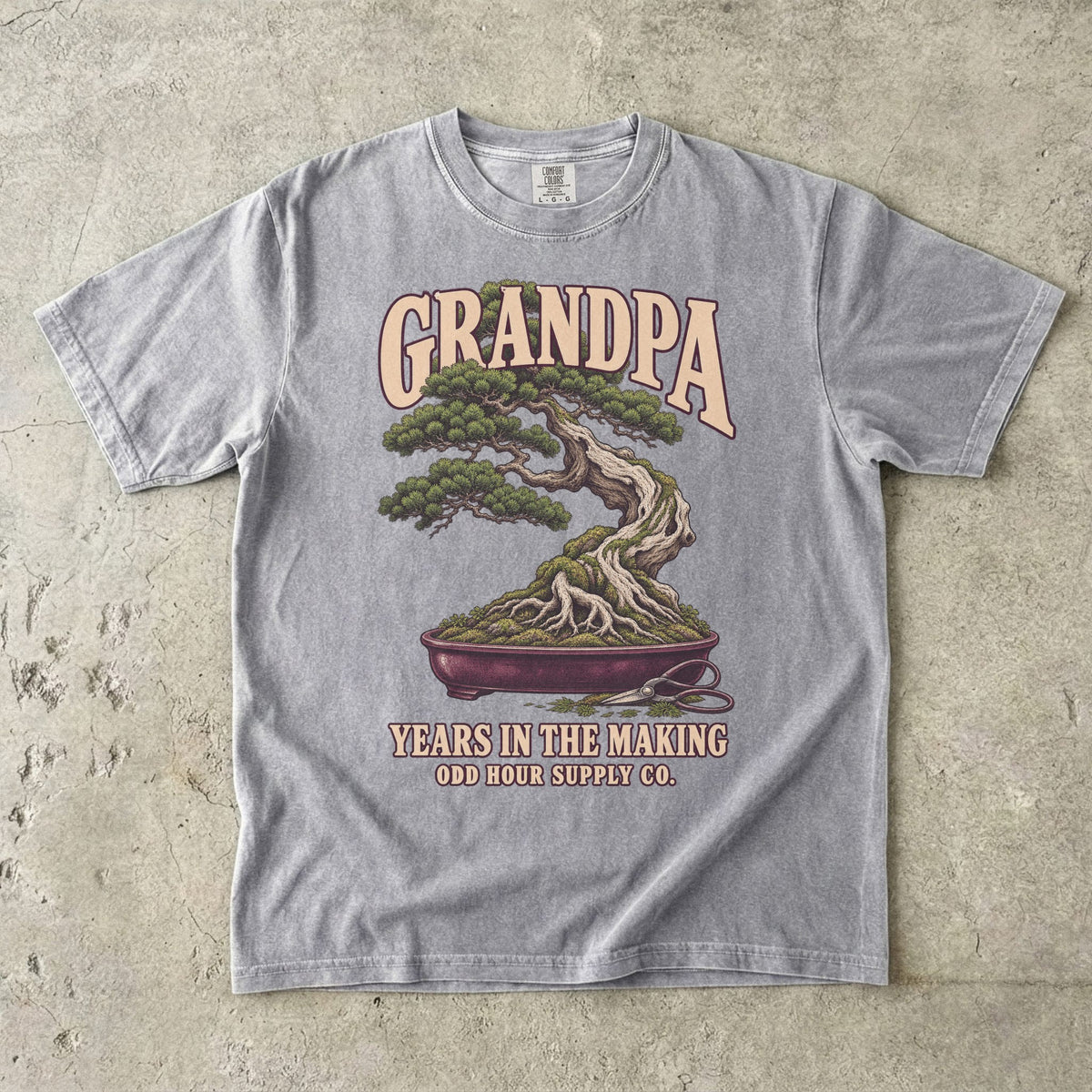 Grey T-shirt with GRANDPA YEARS IN THE MAKING, a bonsai tree, exposed roots and small pruning shears by Odd Hour Supply Co.
