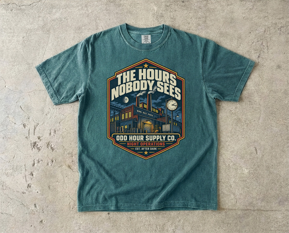 The Hours Nobody Sees vintage badge T-shirt in Blue Spruce, Comfort Colors 1717 front view